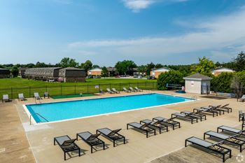 Outdoor swimming pool with lounge chairs and diving board